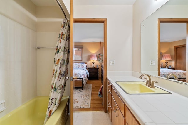 ensuite bathroom with vanity, shower / tub combo with curtain, and tile patterned flooring