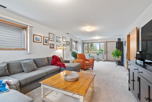living room featuring light colored carpet and a textured ceiling
