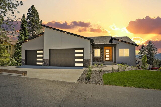 7285 E Columbia Dr, Spokane, WA 99212 - view of front of house with a garage, driveway, stone siding, and a front lawn