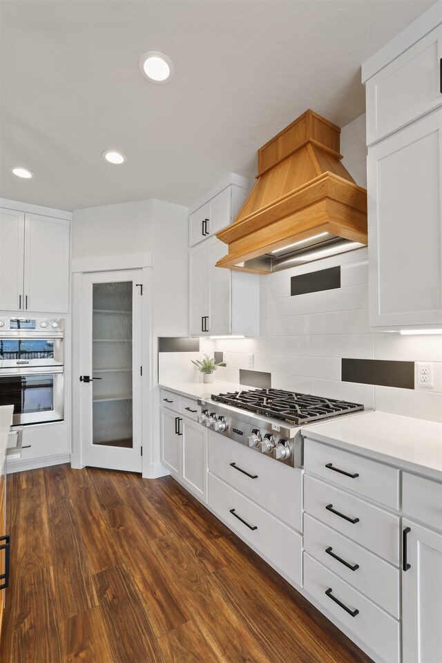 7285 E Columbia Dr, Spokane, WA 99212 - kitchen with custom range hood, appliances with stainless steel finishes, decorative backsplash, white cabinetry, and recessed lighting