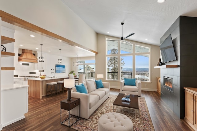 7285 E Columbia Dr, Spokane, WA 99212 - living area featuring dark wood-style flooring, a tiled fireplace, ceiling fan, recessed lighting, and baseboards