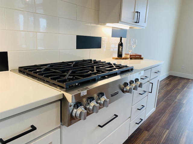 7285 E Columbia Dr, Spokane, WA 99212 - kitchen view of stainless steel gas cooktop, backsplash, light countertops, white cabinetry, and dark wood-style flooring