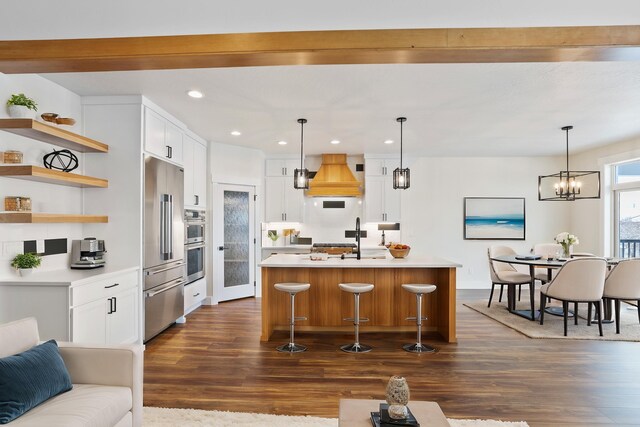 7285 E Columbia Dr, Spokane, WA 99212 - kitchen with dark wood-style flooring, custom exhaust hood, recessed lighting, appliances with stainless steel finishes, and light countertops