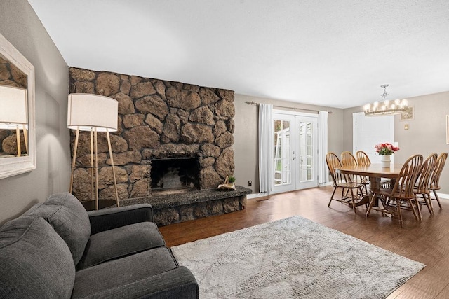 113 W Florence Ave, Spokane, WA 99218 - living area featuring wood finished floors, a chandelier, and a stone fireplace