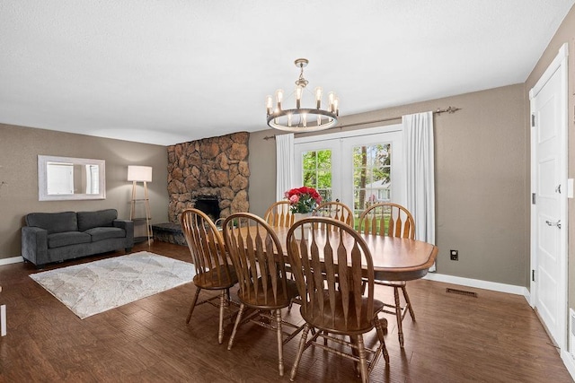 113 W Florence Ave, Spokane, WA 99218 - dining room featuring wood finished floors, a chandelier, a fireplace, and baseboards