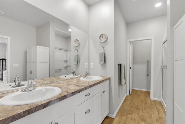 5704 W Jamestown Ln, Spokane, WA 99208 - full bathroom featuring wood finished floors, double vanity, a shower, and baseboards