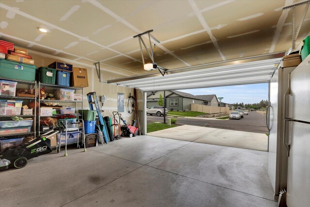 5704 W Jamestown Ln, Spokane, WA 99208 - garage featuring a garage door opener and freestanding refrigerator
