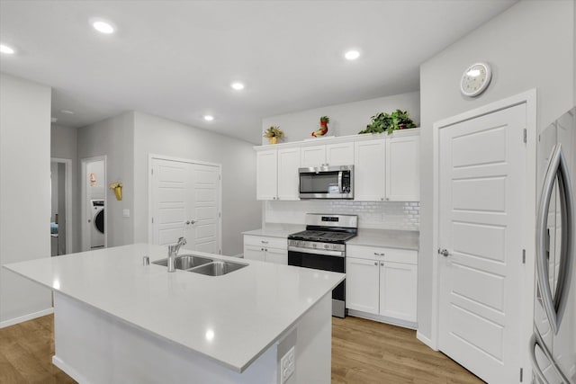 5704 W Jamestown Ln, Spokane, WA 99208 - kitchen featuring appliances with stainless steel finishes, a sink, light wood finished floors, washer / dryer, and recessed lighting