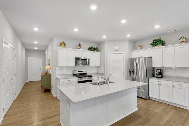 5704 W Jamestown Ln, Spokane, WA 99208 - kitchen with stainless steel appliances, a sink, backsplash, light wood-style floors, and light countertops
