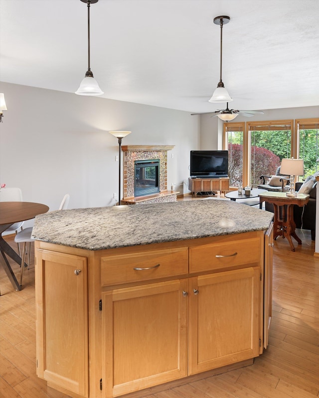 5229 S Altamont Ln, Spokane, WA 99223 - kitchen featuring a kitchen island, a ceiling fan, light stone countertops, and light wood finished floors