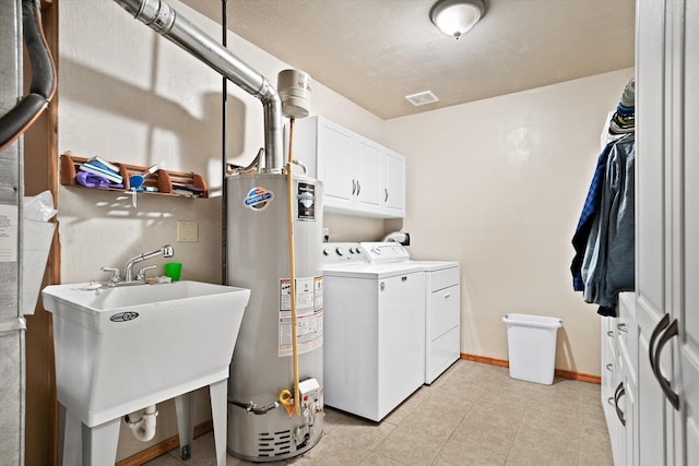 5229 S Altamont Ln, Spokane, WA 99223 - washroom featuring washer and dryer, gas water heater, cabinet space, light tile patterned floors, and baseboards