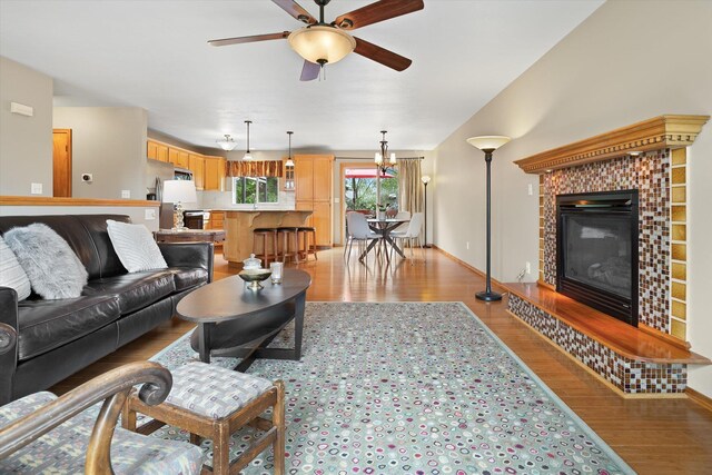 5229 S Altamont Ln, Spokane, WA 99223 - living area with light wood-style flooring, a tile fireplace, ceiling fan, and baseboards
