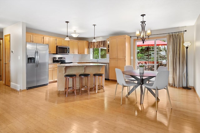 5229 S Altamont Ln, Spokane, WA 99223 - kitchen with appliances with stainless steel finishes, light brown cabinetry, a kitchen island, and a chandelier
