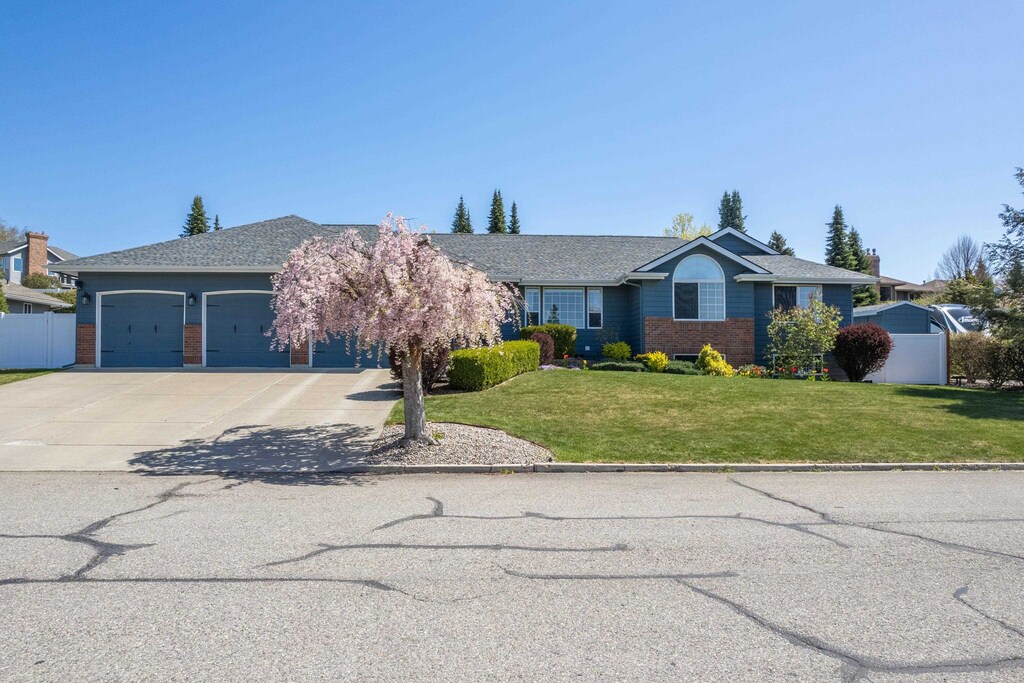 9914 N Comanche Dr, Spokane, WA 99208 - view of front of home featuring a garage, concrete driveway, and brick siding