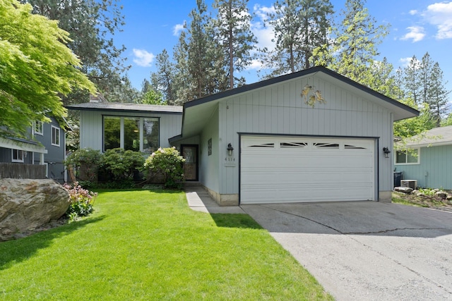 view of front of house with a front yard, an attached garage, and driveway