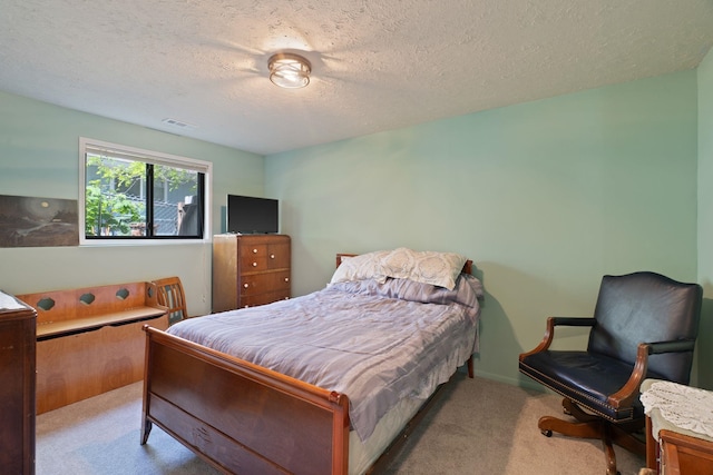 bedroom featuring carpet flooring and a textured ceiling