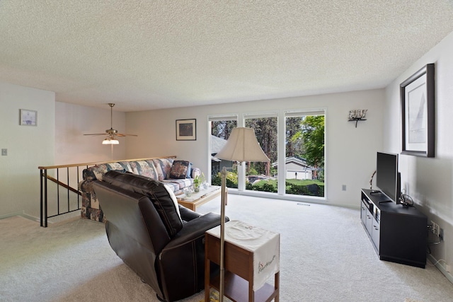 living area with carpet floors, a textured ceiling, and a ceiling fan