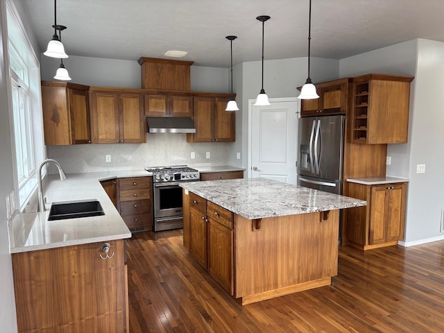 1746 W 14th Ave, Spokane, WA 99204 - kitchen featuring stainless steel appliances, under cabinet range hood, a sink, brown cabinets, and a kitchen island