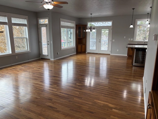 1746 W 14th Ave, Spokane, WA 99204 - unfurnished living room featuring a ceiling fan, baseboards, dark wood-style flooring, a chandelier, and a sink
