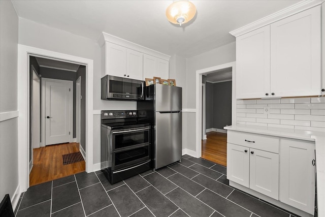 207 W 27th Ave, Spokane, WA 99203 - kitchen featuring stainless steel appliances, light countertops, dark tile patterned floors, and white cabinetry