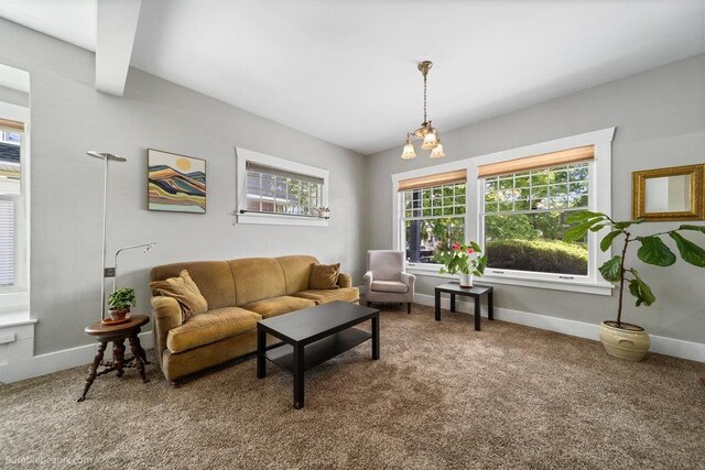 711 E Illinois Ave, Spokane, WA 99207 - carpeted living area with healthy amount of natural light, baseboards, and a chandelier
