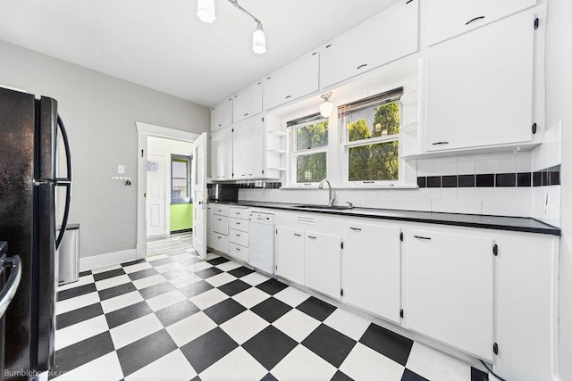 711 E Illinois Ave, Spokane, WA 99207 - kitchen with freestanding refrigerator, a sink, dark countertops, light flooring, and white cabinets