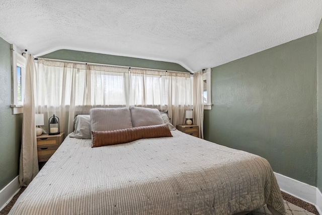 3214 E 29th Ave, Spokane, WA 99223 - bedroom with baseboards, vaulted ceiling, multiple windows, a textured ceiling, and a textured wall
