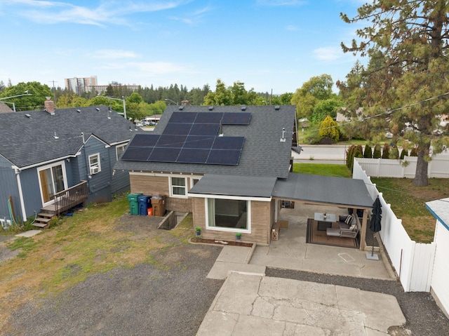 3214 E 29th Ave, Spokane, WA 99223 - back of house featuring a fenced backyard, roof mounted solar panels, roof with shingles, outdoor lounge area, and a deck