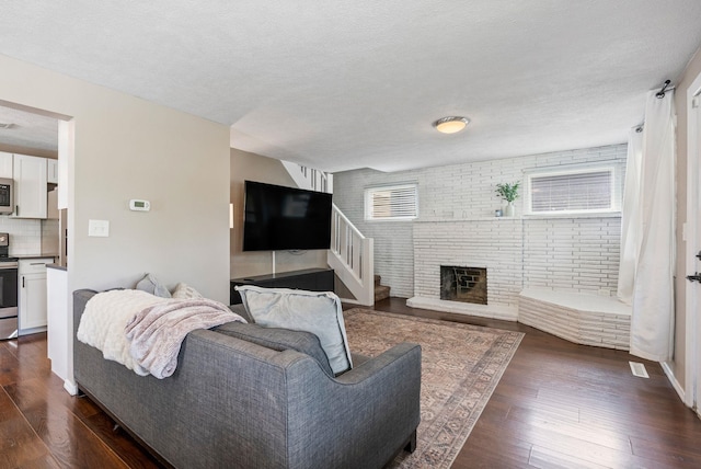3214 E 29th Ave, Spokane, WA 99223 - living room with dark wood-style flooring, a textured ceiling, and a fireplace