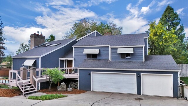 7101 N Greenwood Pl, Spokane, WA 99208 - view of front of home featuring a deck, driveway, roof with shingles, an attached garage, and a chimney