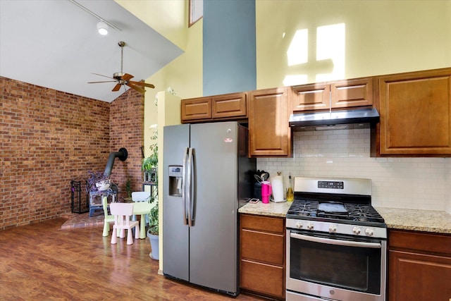 7101 N Greenwood Pl, Spokane, WA 99208 - kitchen featuring stainless steel appliances, under cabinet range hood, a ceiling fan, a wood stove, and backsplash