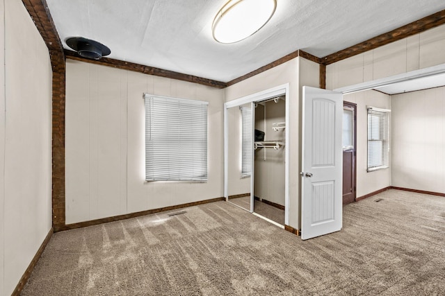 unfurnished bedroom featuring carpet, baseboards, and a closet