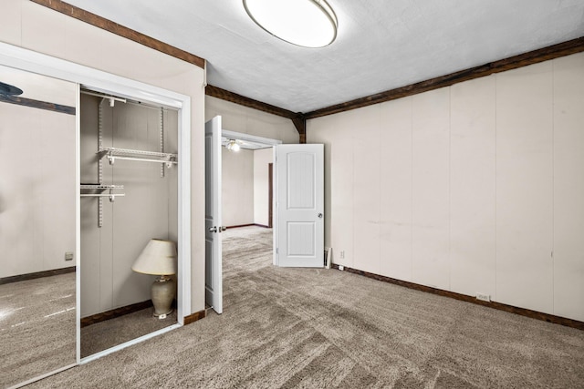 unfurnished bedroom featuring carpet, a closet, and baseboards