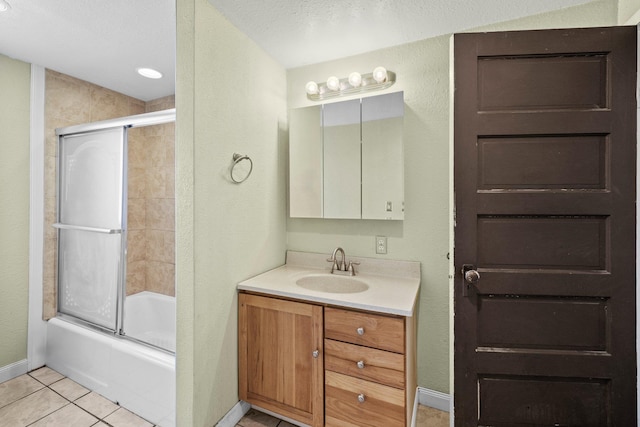 bathroom featuring combined bath / shower with glass door, vanity, tile patterned floors, and baseboards