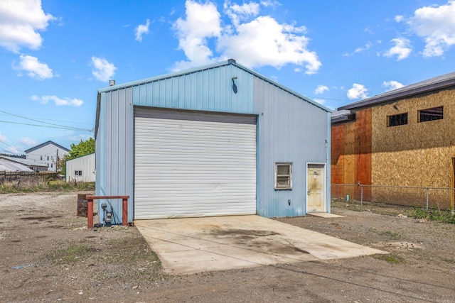 detached garage with fence and driveway