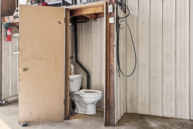 bathroom with unfinished concrete floors and toilet