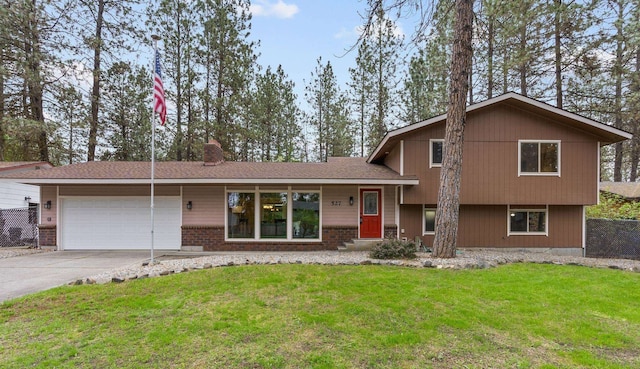 tri-level home with an attached garage, concrete driveway, a front lawn, and a chimney