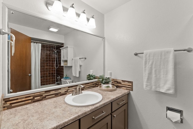 bathroom with a shower with curtain, decorative backsplash, and vanity
