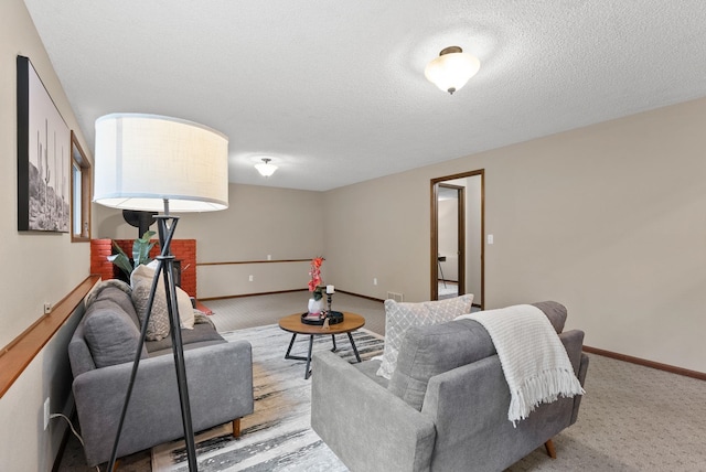 living area featuring carpet floors, a textured ceiling, and baseboards