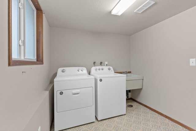 laundry room with separate washer and dryer and baseboards