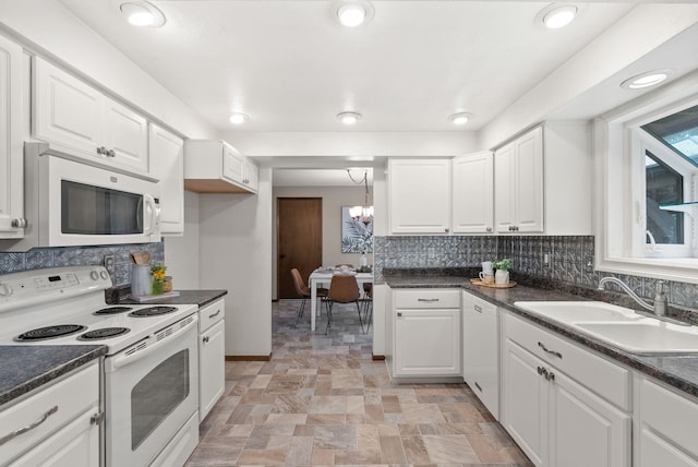 kitchen with white appliances, a sink, dark countertops, and recessed lighting
