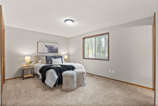 carpeted bedroom featuring baseboards and a textured ceiling