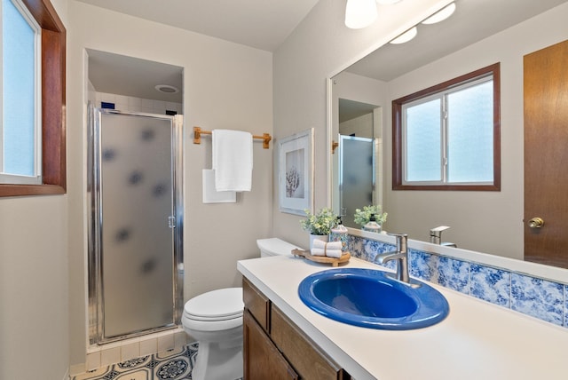 bathroom with a stall shower, vanity, toilet, and tile patterned flooring