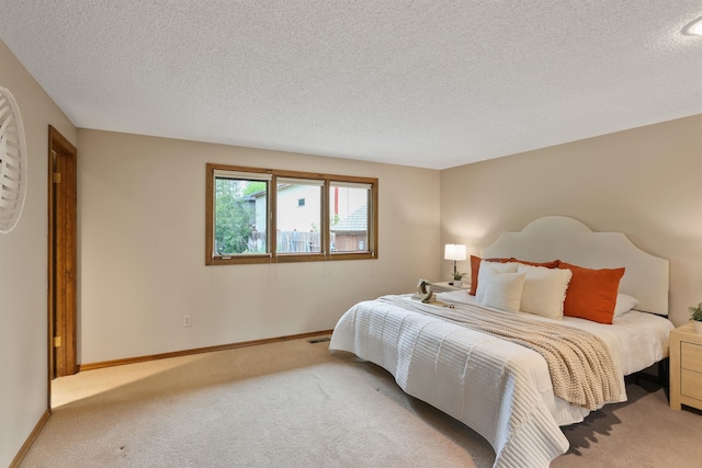 bedroom with carpet flooring, a textured ceiling, and baseboards