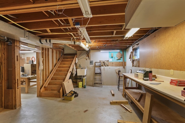 basement with a workshop area and stairway
