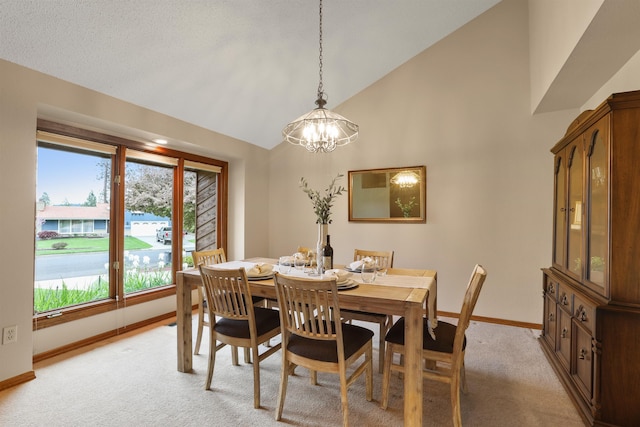 dining space with baseboards, light carpet, a chandelier, and high vaulted ceiling