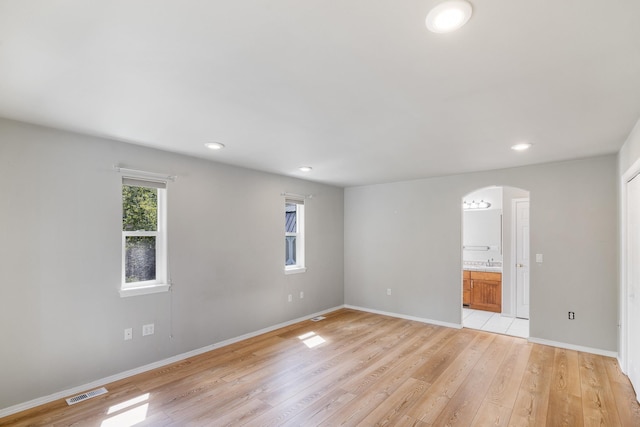 2450 E Black Forest Ave, Post Falls, ID 83854 - unfurnished room featuring arched walkways, light wood-style floors, baseboards, and recessed lighting