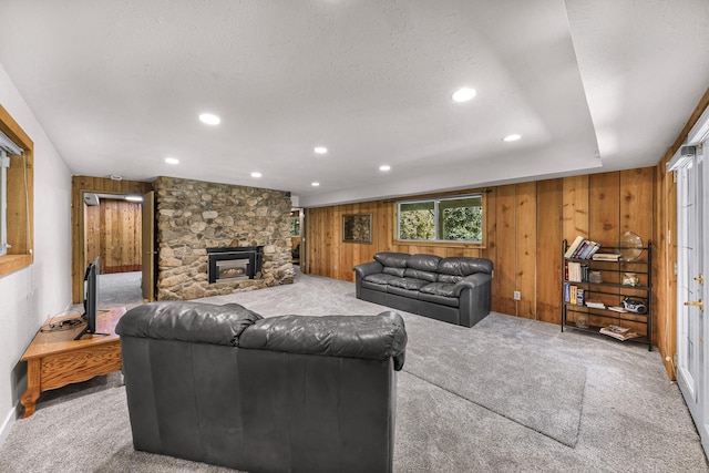 1418 E Blackburn Rd, Wa, WA 98274 - carpeted living room featuring wood walls, a stone fireplace, a textured ceiling, and recessed lighting