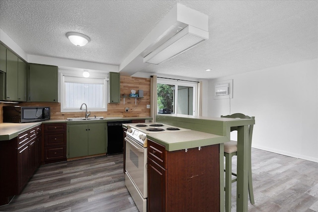2623 W Olympic Ave, Spokane, WA 99205 - kitchen with black appliances, green cabinetry, a textured ceiling, a kitchen breakfast bar, and wood finished floors