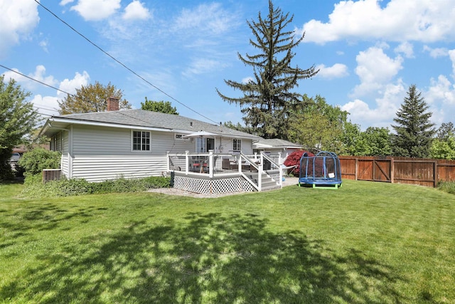 1007 S Bowdish Rd, Spokane Valley, WA 99206 - back of house with a trampoline, a wooden deck, and a chimney